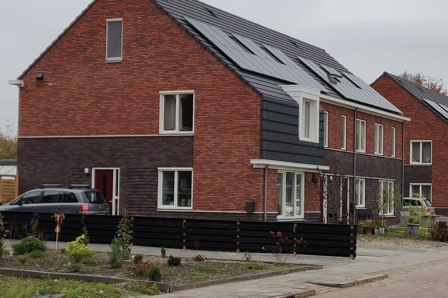 Modernes Backsteinhaus von außen mit Solarpanels auf dem Dach